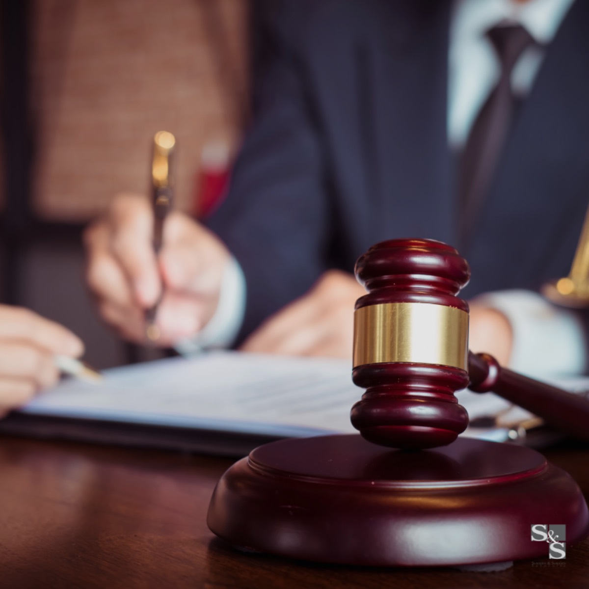 A judge’s gavel on a desk while documents are signed in the background, representing Family Court proceedings in Malta.